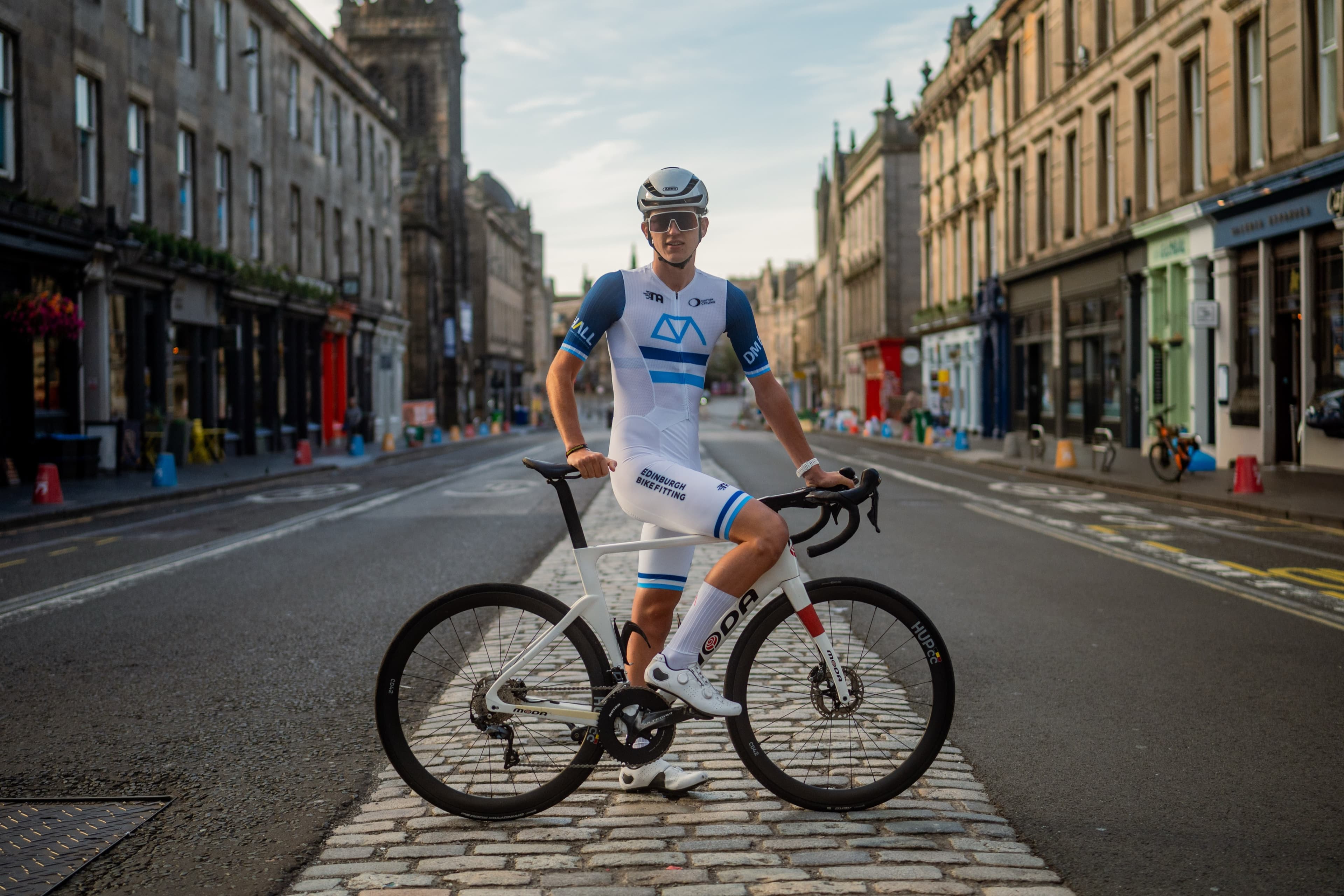 A cyclist facing the camera on an empty Edinburgh street