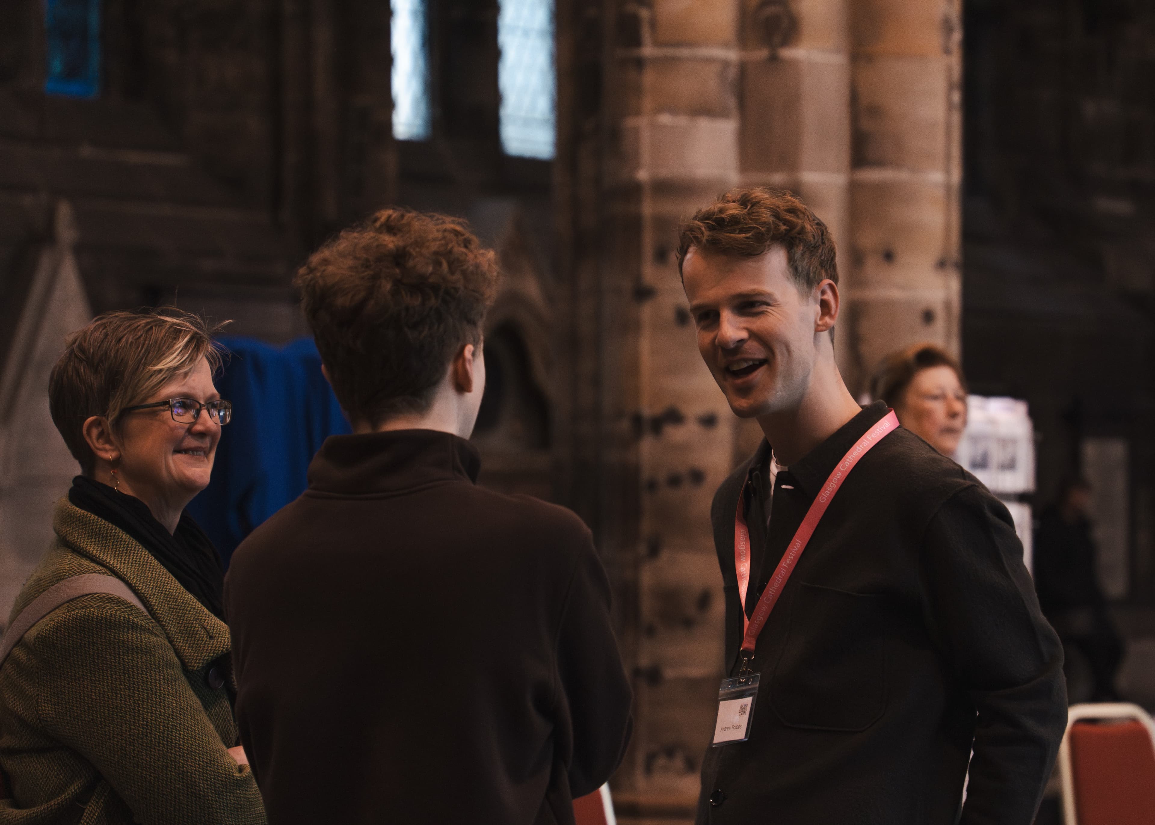 Three attendees chatting inside a cathedral interior